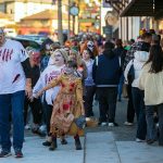 Pedestrians try to sneak by as a horde of zombies marches down First Street during the 10th annual Snohomish Zombie Walk on Saturday, Oct. 28, 2023, in downtown Snohomish, Washington. The yearly event acts a fundraiser for the Snohomish Community Food Bank. (Ryan Berry / The Herald)