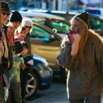A zombie chews on a severed foot to the joy of bystanders during the 10th annual Snohomish Zombie Walk on Saturday, Oct. 28, 2023, in downtown Snohomish, Washington. (Ryan Berry / The Herald)