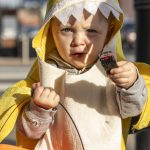Nova Eckaus, 2, poses for a photo during the Downtown Trick or Treat event in Monroe, Washington on Tuesday, Oct. 31, 2023. Children, teens and families walked Main Street to collect candy from local businesses. Dogs sported costumes as well and decorations adorned buildings. (Annie Barker / The Herald)
