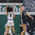 Arlingtons Jackson Trotter leaps in the air to try and block a shot by Jacksons Seamus Williams during the game on Tuesday, Nov. 28, 2023 in Everett, Washington. (Olivia Vanni / The Herald)