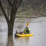 Snohomish Regional Fire & Rescue paddle in to shore with a man and his dog from a portion of Al Borlin Park where they were stranded with three other people on Tuesday, Dec. 5, 2023 in Monroe, Washington. (Olivia Vanni / The Herald)