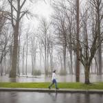 A woman walks past a flooded River Park on Tuesday, Dec. 5, 2023 in Sultan, Washington. (Olivia Vanni / The Herald)
