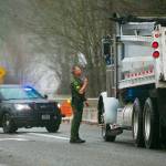 A Snohomish County deputy blocks off Highway 530 at Twin Rivers Park and begins turning drivers back towards Arlington during heavy flooding on Tuesday, Dec. 5, 2023, in Arlington, Washington. (Ryan Berry / The Herald)