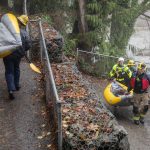 Snohomish Regional Fire and Rescue crews carry their inflatable rescue boat in Al Borlin Park on Tuesday, Dec. 5, 2023 in Monroe, Washington. (Olivia Vanni / The Herald)