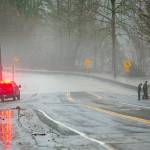 A group of park rangers have a look at the flood waters along the Stillaguamish on Highway 530 after closing down Twin Rivers Park during heavy flooding on Tuesday, Dec. 5, 2023, in Arlington, Washington. (Ryan Berry / The Herald)