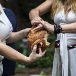 Pagans from around Puget Sound break bread during the Lammas and Wicker Man ritual at the Aquarian Tabernacle Church in Index, Washington, on Aug. 5, 2023. According to the church, the bread signifies an abundant harvest, and that the gods will ensure their needs are provided for if each person does their part for the group. (Annie Barker / The Herald)