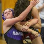 A Kamiak wrestler reaches around for the head of her opponent on Wednesday, Dec. 13, 2023 in Everett, Washington. (Olivia Vanni / The Herald)