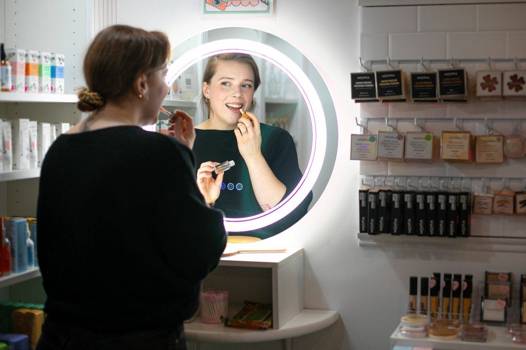 Sarah Jean Muncey-Gordon applies some BITCHSTIX lip oil. (Ryan Berry / The Herald)