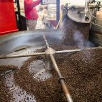 Trevor Peterson, a roaster for Vista Clara Coffee, watches as a freshly roasted batch falls out of the roaster to be cooled on Monday, Jan. 15, 2024 in Snohomish, Washington. (Olivia Vanni / The Herald)
