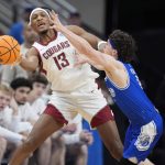 Washington States Isaac Jones passes around Drakes Conor Enright during the second half of an NCAA Tournament game Thursday in Omaha, Neb. (AP Photo/Charlie Neibergall)