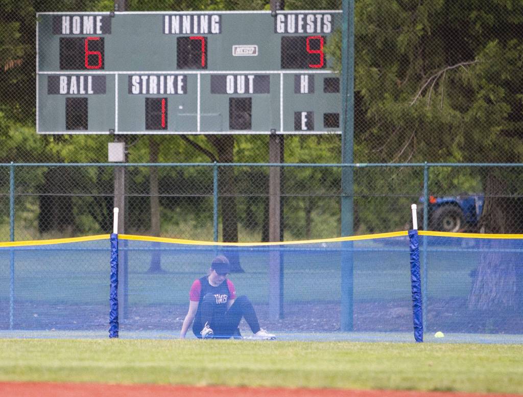 Snohomishs Avery Clark begins to stand up after chasing a ball over the back net during the 3A state softball semifinal game against Garfield on Saturday, May 25, 2024 in Lacey, Washington. (Olivia Vanni / The Herald)