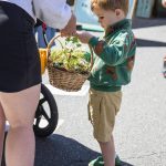 Benjamin Elen, 3, hands his mother a flower basket he picked out during Sorticulture on Friday, June 7, 2024, in Everett, Washington. (Olivia Vanni / The Herald)