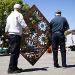 Two men carry a large metal work through Sorticulture on Friday, June 7, 2024, in Everett, Washington. (Olivia Vanni / The Herald)