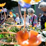 Nedra Vranish, left, and Karen Thordarson, right browse colorful glass flowers at Fuse4U during Sorticulture on Friday, June 7, 2024, in Everett, Washington. (Olivia Vanni / The Herald)