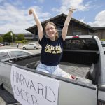 Arlington High School senior Alyssa Acosta sits in the back of her mother’s truck still decorated from the senior parade on Wednesday, June 12, 2024 in Arlington, Washington. Acosta, who has been cheering for 8 years, will be attending Harvard in the fall on a full cheer scholarship. (Olivia Vanni / The Herald)