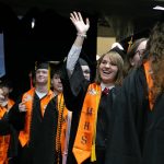 Students wait in the wings and wave to family before the processional during Monroe High Schools 2024 commencement on Wednesday, June 12, 2024, at Angel of the Winds Arena in Everett, Washington. (Ryan Berry / The Herald)