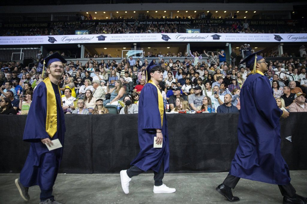 Graduates file into the arena during Arlington High School graduation at Angel of the Winds Arena on Thursday, June 13, 2024, in Everett, Washington. (Olivia Vanni / The Herald)