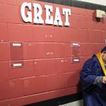 A student adjusts their robe during Arlington High School graduation at Angel of the Winds Arena on Thursday, June 13, 2024, in Everett, Washington. (Olivia Vanni / The Herald)