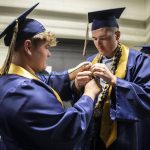 Parker Kinney, left, and Camden Matter try to fix a loose honor cord before walking at Arlington High School graduation at Angel of the Winds Arena on Thursday, June 13, 2024, in Everett, Washington. (Olivia Vanni / The Herald)