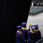 Students wave at family and friends before the start of Arlington High School graduation at Angel of the Winds Arena on Thursday, June 13, 2024, in Everett, Washington. (Olivia Vanni / The Herald)