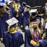 Students gather with decorated graduation caps before the start of Arlington High School graduation at Angel of the Winds Arena on Thursday, June 13, 2024, in Everett, Washington. (Olivia Vanni / The Herald)