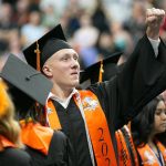A graduate waves to the crowd in the stands during Monroe High Schools 2024 commencement on Wednesday, June 12, 2024, at Angel of the Winds Arena in Everett, Washington. (Ryan Berry / The Herald)
