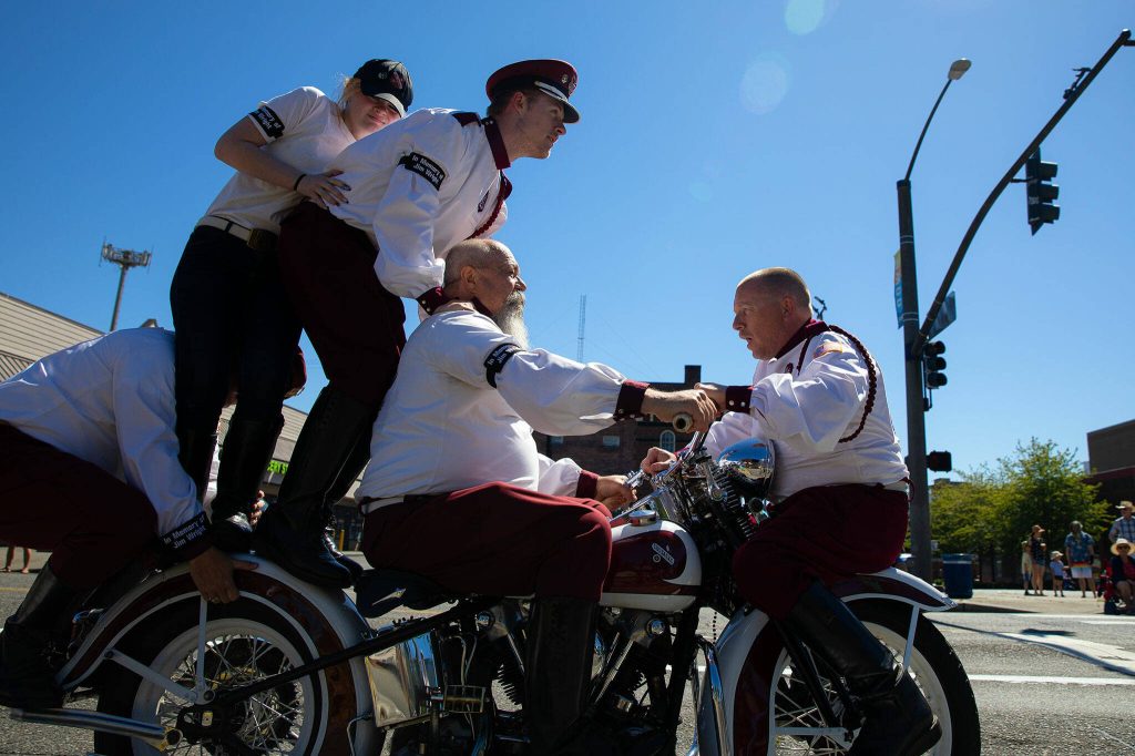 The Seattle Cossacks Motorcycle Stunt Team pile onto a motorcycle during Everetts Fourth of July Parade on Thursday, July 4, 2024, in downtown Everett, Washington. (Ryan Berry / The Herald)