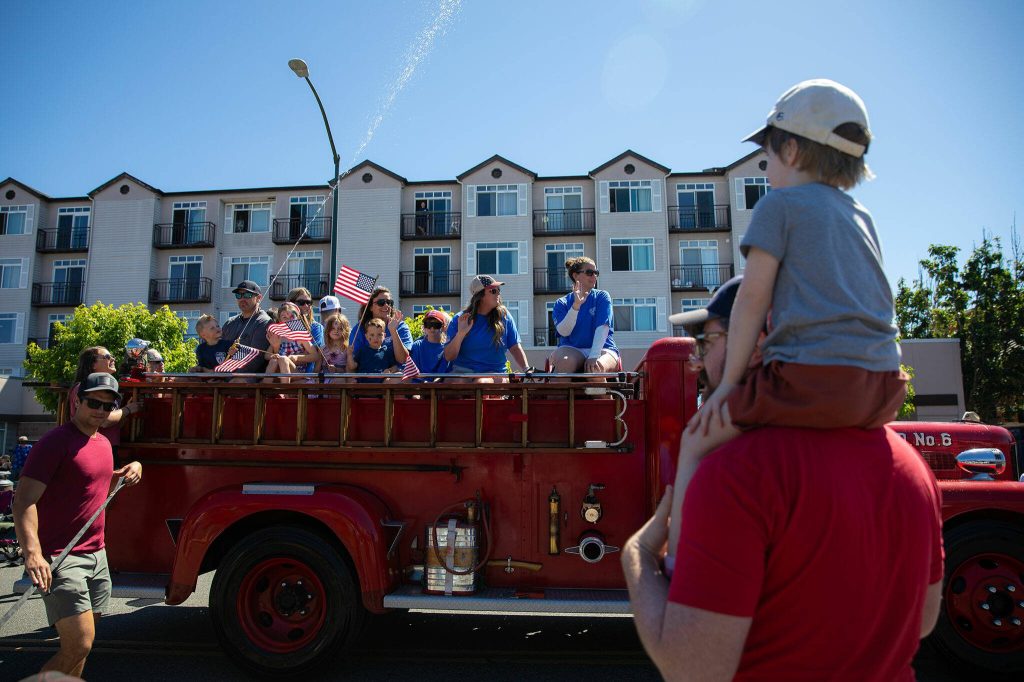 An old fire engine goes by during Everetts Fourth of July Parade on Thursday, July 4, 2024, in downtown Everett, Washington. (Ryan Berry / The Herald)