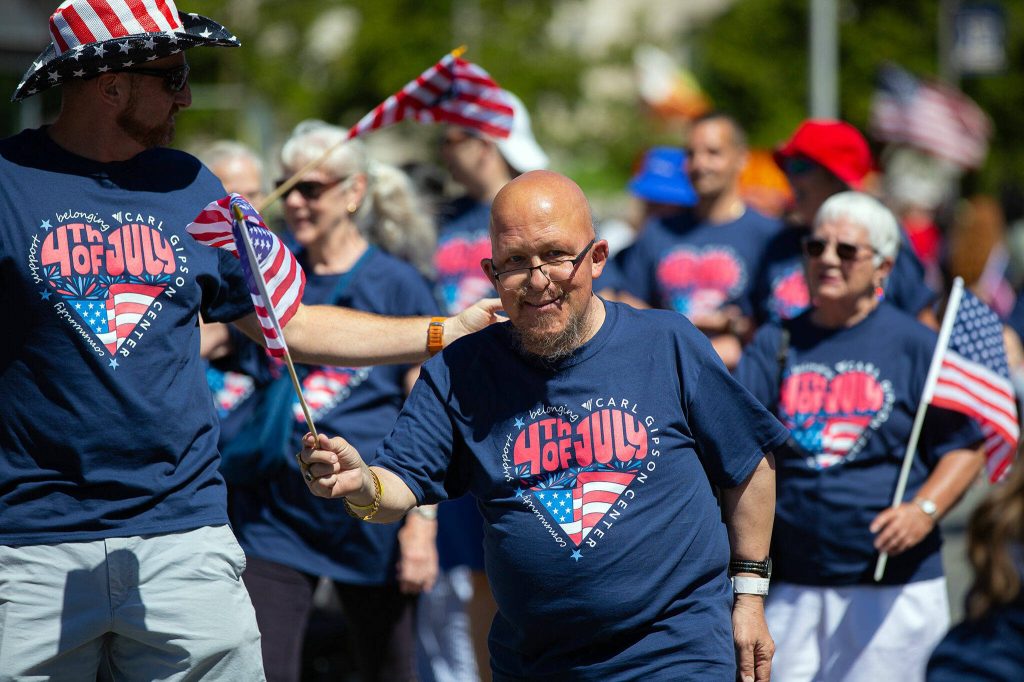 People marching with the Carl Gipson Center head down Colby during Everetts Fourth of July Parade on Thursday, July 4, 2024, in downtown Everett, Washington. (Ryan Berry / The Herald)