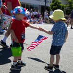 Two children exchange candy during Everetts Fourth of July Parade on Thursday, July 4, 2024, in downtown Everett, Washington. (Ryan Berry / The Herald)