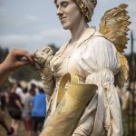 Faye, the living statue, accepts tips in their pitcher during the Washington Midsummer Renaissance Faire at Sky Meadows Park in Snohomish, Washington on Sunday, Aug. 6, 2023. (Annie Barker / The Herald)