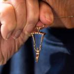Kim Knor holds up a hold skydiver necklace charm that she wears on Wednesday, Aug. 14, 2024 in Snohomish, Washington. (Olivia Vanni / The Herald)