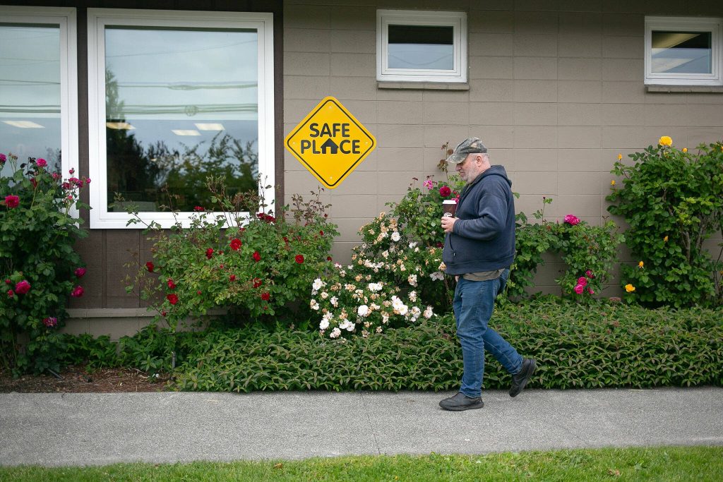 George Beard walks into the Stanwood Library with coffee in hand on May 23. (Ryan Berry / The Herald)