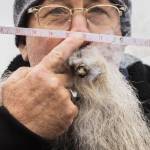 Jeff Raye smokes a cigar while he holds a tape measure to his nose during the Guinness World Record Beard Chain Attempt on Friday, Nov. 1, 2024 in Everett, Washington. (Olivia Vanni / The Herald)