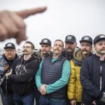 Dozens of people with mustaches clipped together wait to be measured for a Guinness World Record Mustache Chain Attempt on Friday, Nov. 1, 2024 in Everett, Washington. (Olivia Vanni / The Herald)