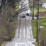 A person shovels debris next a tree that fell across 103rd Avenue Southeast and onto power lines that closed a portion of the road on Wednesday, Nov. 20, 2024 in Lake Stevens, Washington. (Olivia Vanni / The Herald)