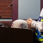 Rhys Stenhouse, 13, sets his signed AquaSox hat on the podium before speaking to the Everett City Council before a vote on the site for the Everett AquaSox stadium on Wednesday, Dec. 18, 2024, in Everett, Washington. (Olivia Vanni / The Herald)