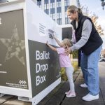 Carli Brockman lets her daughter Carli, 2, help push her ballot into the ballot drop box on the Snohomish County Campus on Tuesday, Nov. 5, 2024 in Everett, Washington. (Olivia Vanni / The Herald)