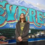Everett P. Fog, 15, in front of an Everett mural along Colby Avenue in Everett. (Olivia Vanni / The Herald)