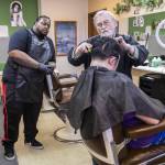 AHC Barber & Beauty College owner Don Sharrett talks barber student John Wrice through his trimming technique on March 14 in Everett. (Olivia Vanni / The Herald)