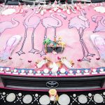 Flamingos and beachy trinkets cover the hood of Marty Vales art car. (Olivia Vanni / The Herald)