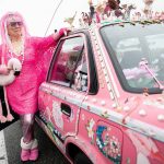 Marty Vale stands next to her hot pink and trinket covered Toyota Corolla on Thursday, Dec. 12, 2024 in Everett, Washington. (Olivia Vanni / The Herald)
