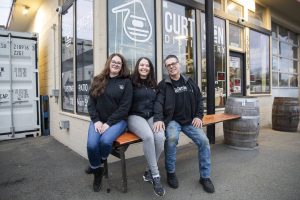 Curtson Distillery owners Robert Thompson, right, Malinda Curtis, center, and employee Sarah Trocano, left, at the distillery in Sultan. (Olivia Vanni / The Herald)