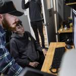 Jonathon DeYonker, left, helps student Dominick Jackson upload documentary footage to Premier at The Teen Storytellers Project on Tuesday, April 29, 2025 in Everett, Washington. (Olivia Vanni / The Herald)