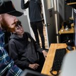 Jonathon DeYonker, left, helps student Dominick Jackson upload documentary footage to Premier at The Teen Storytellers Project on Tuesday, April 29, 2025 in Everett, Washington. (Olivia Vanni / The Herald)