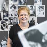 Whats Up With That? columnist Andrea Brown with a selection from hundreds of black-and-white celebrity glossies from The Daily Herald photo vault that she will give away at a pop-up in August. The photos were sent by studios to use for page paste-up in the pre-digital era. (Olivia Vanni / The Herald)