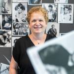 What’s Up columnist Andrea Brown with a selection of black and white glossy promotional photos on Wednesday, June 18, 2025 in Everett, Washington. (Olivia Vanni / The Herald)