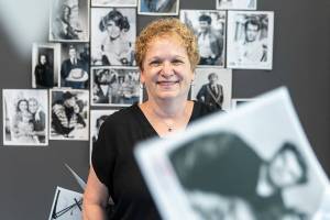 What’s Up columnist Andrea Brown with a selection of black and white glossy promotional photos on Wednesday, June 18, 2025 in Everett, Washington. (Olivia Vanni / The Herald)