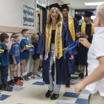 Everett High School graduate Gwen Bundy high fives students at her former grade school Whittier Elementary during their grad walk on Thursday, June 12, 2025 in Everett, Washington. (Olivia Vanni / The Herald)