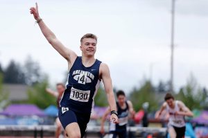 Arlington’s Parker Duskin throws up a hand after defeating the competition in the 3A boys 300 hurdles at the 2022 WIAA State Track & Field Championships at Mount Tahoma High School in Tacoma, Washington. (Ryan Berry / The Herald)